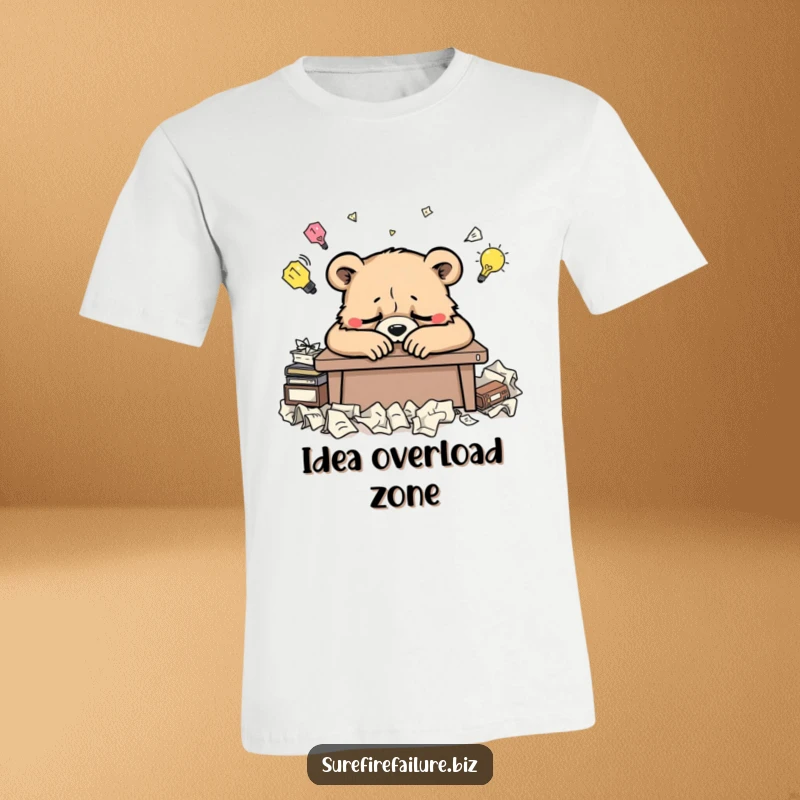 Funny bear t-shirt featuring a weary animal slumped over a desk surrounded by crumpled ideas, perfect for creative burnout humor